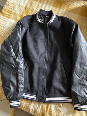 Svart bomberjacka med skinnärmar, strlk XXS - Svart jacka med ärmar i skinnimitation. Knappt använd. 