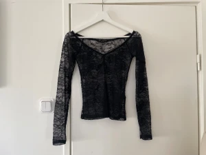 Svart spetstopp - Säljer en svart långärmad topp i transparent spets från Light Before Dark men den är köpt från Urban Outfitters. Säljer på grund av att den inte kommer till användning. Skriv om ni har frågor.🖤