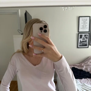 Ljusrosa v-ringad tröja från Skill - Säljer en ljusrosa v-ringad tröja från Skill. Tröjan har lång ärm.