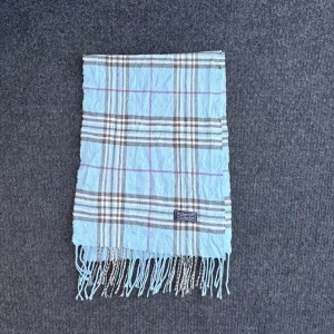 Burberry scarf - Burberry-scarf som är 100% äkta. Mindre defekter kan förekomma enligt bild men inget märkvärdigt då de är vintage. Snabb leverans och trygg handel då vi har 7 års erfarenhet i branschen. Vid frågor eller bud, skicka gärna ett meddelande. 1015
