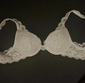 Vit spetsig bh med broderade detaljer - Säljer en vit bh med spets, i stl 70a. Säljer på grund av ingen användning 