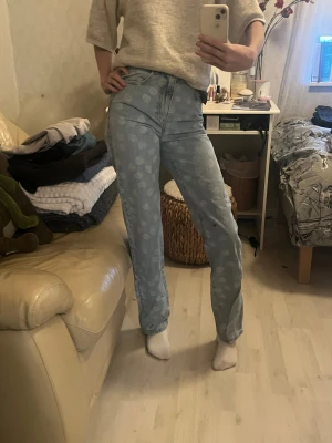 Blommiga jeans - Säljer högmidjade jeans från bikbok i modellen 90’s straight, pga kommer aldrig till användning. Har använts några gånger. Storlek i w25 L32
