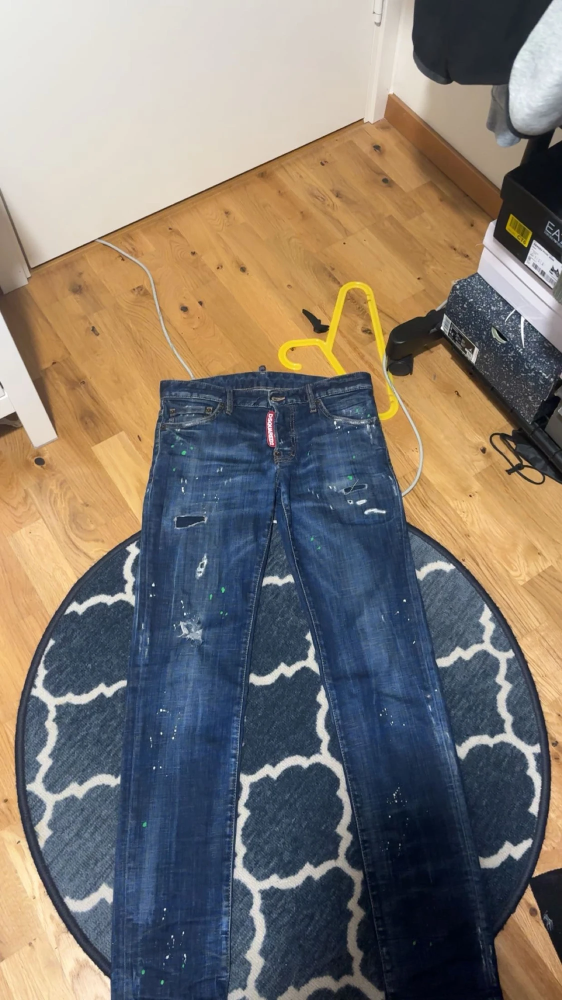 Blå jeans med slitningar och färgstänk