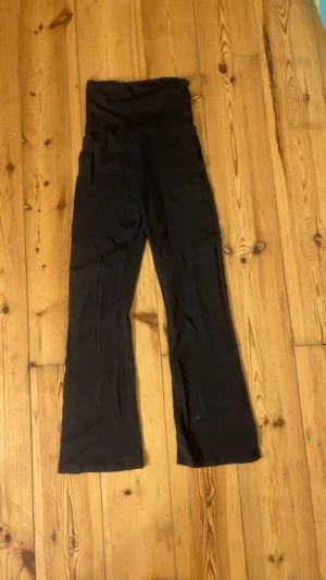 Svarta yogapants - Svarta yoga pants som man viker ner och bred linning. Byxorna har ett wide ben och är tillverkade i mjukt material som känns skönt mot huden. Perfekta för chill dagar eller när du vill ha en avslappnad look.