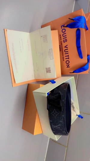 Louis Vuitton svart monogram bälte - Säljer ett Louis Vuitton bälte i svart skinn med klassiskt monogrammönster och stor LV-logga i svart metall. Bältet har en stilren och lyxig look, perfekt för dig som vill sticka ut med en ikonisk accessoar. Kommer med originalbox och påse.