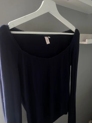 Mörkblå långärmad topp från NA-KD - En stilren mörkblå långärmad topp från NA-KD med rundad halsringning och diskret spetskant. Perfekt att matcha med jeans eller kjol för en enkel men snygg look. Aldrig använt den bara testad 