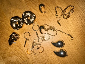 Mix av guldiga och silvriga smycken - Säljer ett coolt smyckeskit med flera guldiga örhängen i olika former, chunky ring, två halsband med kedja och ett par silvriga droppformade örhängen. Här finns både hoops, stjärnor, spikes och månar – perfekt för dig som gillar att mixa stilar och uttryck.