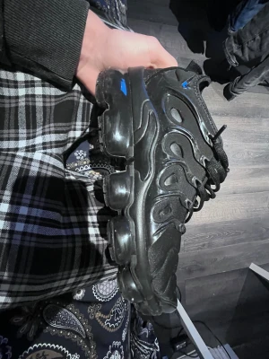 Svarta Nike Vapormax sneakers - Svarta Nike Vapormax sneakers med chunky, transparent sula och coola vågformade detaljer på ovansidan. Skorna har snörning och meshpartier för extra ventilation. Snyggt och futuristiskt utseende som sticker ut, perfekt för dig som gillar streetstyle.