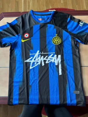 Inter Milan x Stüssy x Nike edition. Strl. M - Inter Milan tröja i Stüssy edition. Passar perfekt både på fotbollsplanen och utanför för den som gillar street looks