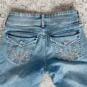 Ljusblåa bootcut jeans med detalj på bakfickan  - Finns lite täcken på användning, bara att kontakta vid frågor💗💗