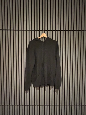 Svart hoodie i kashmir från John Henric - Svart hoodie från John Henric i mjuk kashmir. Tröjan är väldigt sparsamt använd och har inga defekter och är i inorinsip nyskick hör gärna av er angående prisförslag då inget är skrivet i sten, ordinarie pris är 2799.