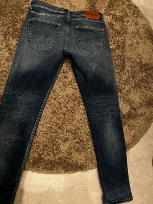 Replay Willbi slim fit jeans blå - Snygga Replay Willbi jeans i regular slim fit med klassisk femficksdesign. Jeansen är mörkblå med slitningar och ljusare partier framtill för en cool, använd look. Tillverkade i jeansmaterial med stretch för extra komfort.