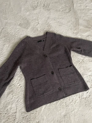 Stickad tröja med fickor - En väldigt snygg och stilren stickad tröja från Lager 157. Tröjan är brun och har knappar samt fickor framtill. Den är knappt använd och helt slutsåld på hemsidan.