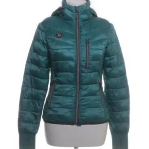 Ridjacka - Uhip  - Snygg grön pufferjacka med huva och dragkedja framtill. Jackan har quiltad design, tre fickor med dragkedja och en liten patch på bröstet. Perfekt för kyliga dagar och ger en sportig vibe. OBS!⚠️ inte min bild.                Skriv om ni vill ha fler bilder, dock är den exakt som på bilden men lite större. 💖
