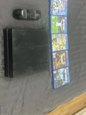 PlayStation 4 (PS4) med spel och laddstation - Sony PlayStation 4 i bra skick, med mindre ytslitage. Inkluderar laddstation för handkontroller och fem populära spel: Ratchet & Clank, Fc 25, FIFA 17, Call of Duty: Advanced Warfare och Just Cause 4. Perfekt för dig som vill komma igång direkt! Finns kablar och kontroller till sista pris