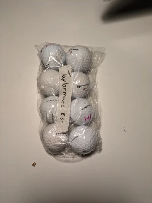 8st Golfbollar (Taylormade) - Bilden visar inga västar utan ett paket med golfbollar från Taylormade. Ingen väst att beskriva.