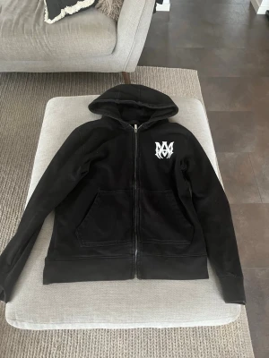 Svart amiri huvtröja med dragkedja  - En svart amiri hoodie med vita detaljer jätte skön bra inför våren 