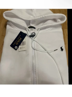 Ralph lauren zip hoodie - Tjenare! Jag säljer min vita ralph lauren hoddie prislappen är av klippt men du får fortfarande med den. Tjocktröjan är använd 3 gånger säljer den för använder inte den. Vid snabba affärer kan priset diskuteras.