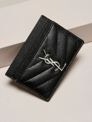 Svart quiltad plånbok från YSL - Snygg svart plånbok från YSL i quiltat skinn med silverfärgad logga framtill. Smidig och stilren design med plats för kort. Perfekt accessoar för dig som gillar lyxiga detaljer och klassisk look.