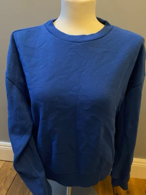 Blå crewneck sweatshirt - En enkel och stilren blå crewneck sweatshirt med rund halsringning och långa ärmar. Tillverkad i mjuk bomull som känns skön mot huden. Perfekt för dig som gillar en clean och avslappnad look. Priset kan diskuteras. Skriv vid frågor😊