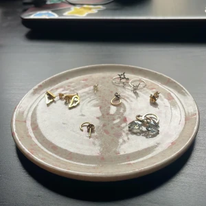 Handgjord Smyckesbricka, smyckestallrik  - Köpt på Öppethus i Gustavsberg Hantverksstudio! Legat smycken på men ej mat!. Superfintskick och är i Drejat keramik med glasyr över hela ytan, dock inte på baksidan!Cirka 4,5 i Diameter! Smycken finns att köpa i separata inlägg detta är enbart för tallriken! Frågor? Kom DM!