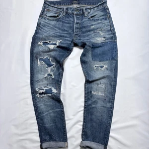 Ralph Lauren Jeans - Snygga blå jeans från Polo Ralph Lauren med schyssta slitningar och unika detaljer.                          Stolek: 32.                                                                            Skick: 9/10.                                                                          Tveka inte att höra av dig vid minsta fundering!