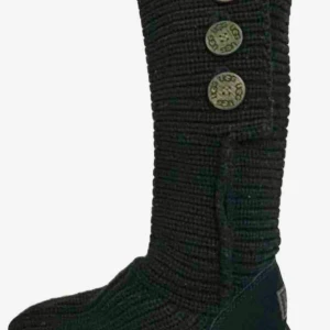 Svarta stickade UGG boots med knappar - Säljer ett par svarta stickade UGG boots med tre dekorativa knappar på sidan. Skorna har platt sula och rund tå, samt detaljer i mocka vid hälen. Perfekta för dig som gillar mysig och cool stil under höst och vinter. Storlek 38, stövlarna är i nyskick.