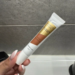 Max Factor Miracle Pure Bronzer - Max Factor Miracle Pure Golden Glow Bronzer i tub, färg medium to deep med varm gyllene ton. Innehåller squalane och hyaluronsyra för extra glow. Vegansk formula i smidig plastförpackning, perfekt för att skapa solkysst look.