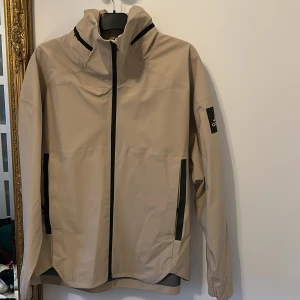 Adidas vindjacka - ny  - Helt ny vindjacka från adidas. Väldigt fin och hållbart material för alla aktiviteter eller bara att bekämpa regnet. Använt 1 gång i aktivitet syfte. Snygg och har inbyggt luva som göms i nacken.