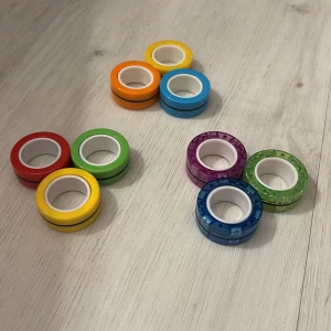 Magnetiska finger rings fidget leksak - Säljer 12 magnetiska finger rings i olika färger. Perfekt som fidget-leksak för stresslindring och fokus. Ringarna är i mycket fint skick, utan synligt slitage. Kan användas för tricks, staplas eller snurras på fingrarna. Passar både barn och vuxna.