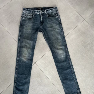 Replay jeans - Snygga Replay jeans i blå tvätt med slitningar och klassiska fem fickor. Slim fit-modell med normal midja. Jeansen har Replay-logga på bakfickan och patch i skinn vid linningen. Perfekt för dig som gillar en modern och stilren look. Skicket är mycket bra och inga tecken på användning! Lappen är avklippta men jag gissar på att storleken är ungefär 32/32, passar bra på killen som är ungefär 185cm lång! Hör av dig vid minsta fundering! Mvh EM_resell
