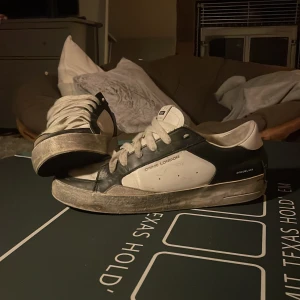 Svarta och vita sneakers Crime London - Snygga sneakers från Crime London i svart och vitt med rund tå och platt sula. Skorna har snörning och en cool kontrast mellan färgerna. Perfekta för dig som gillar streetstyle och vill ha ett par trendiga skor med unik design.