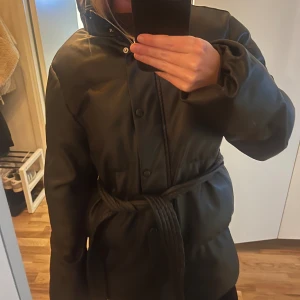 Jacka  - Snygg vinterjacka från nakd med knytning, som går att ta av och på. Lite skinnaktig i materialet. Fint skick 
