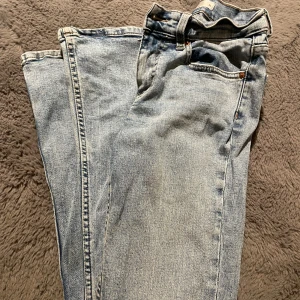 Ljusblå jeans från Ginatricot - Ljusblå jeans med klassisk femficksdesign och raka ben. Jeansen har normal passform och är tillverkade i denim med synliga sömmar och knappgylf. Perfekta för dig som gillar en enkel och tidlös look. Storlek 34.