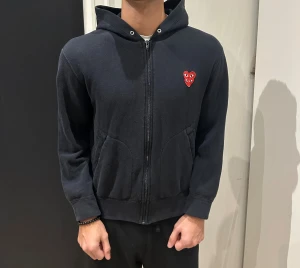 Svart hoodie från Comme des Garçons - Svart hoodie med dragkedja från Comme des Garçons. Barn storlek M men passar S/XS. Säljer billigt. 699kr