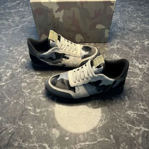 Valentino Rockrunner Garavani camo  - Snygga Valentino Rockrunner Garavani med grått och svart camouflage-mönster. Skorna har använts två tre gånger, men visa sig var för stora. Perfekt för dig som vill ha en unik och lyxig touch på din streetstyle 