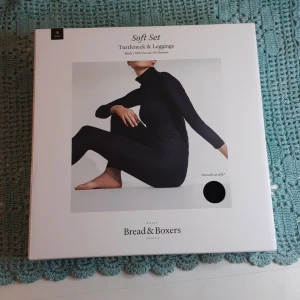 Svart polotröja från Bread & Boxers - Mjuk och skön svart polotröja från Bread & Boxers, tillverkad i 94% viskos och 6% elastan. Tröjan har lång ärm och en klassisk polokrage som ger en clean och stilren look. Perfekt att matcha med leggings för en enkel och snygg outfit.