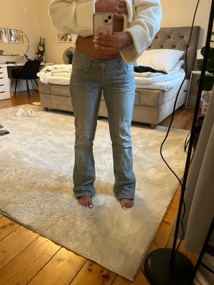 Levis 517 ljusblå bootcut jeans - Säljer ett par Levis 517 jeans i ljusblå tvätt med klassisk bootcut passform. De har låg midja, fem fickor och subtila slitningar för en cool vintagekänsla. Jeansen är gjorda i mjukt denim och har knapp- och dragkedja framtill.