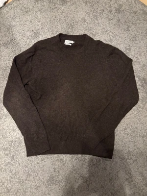 Mörkbrun ulltröja från East West - Snygg mörkbrun tröja från East West i mjuk lammull. Storlek L men sitter mer som en S/M. Vid frågor eller funderingar tveka inte på att höra av er!