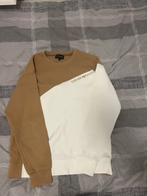 Beige och vit tröja Emporio Armani - Lägg bud så priset kan diskuteras. Säljer en  beige och vit tröja från Emporio Armani i storlek S. Den sitter bra och är knappt änvänd.  