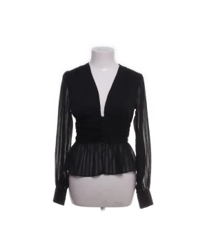 Svart blus med v-ringning från Boohoo - Säljer en svart blus från Boohoo med v-ringad front och transparenta, långärmade partier. Blusen har ett randigt mönster i tyget och en figurnära midja som ger en snygg siluett. Perfekt för dig som gillar trendiga detaljer och stilren look.