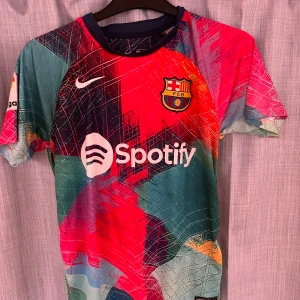 FC Barcelona matchtröja Lewandowski - Säljer en FC Barcelona matchtröja från Nike med Lewandowski och nummer 9 på ryggen. Tröjan har ett färgstarkt mönster i rött, blått, grönt och orange, samt klubbmärke och sponsortryck på bröstet. Perfekt för dig som älskar fotboll och Barca! Skriv om ni har frågor 🤝😄