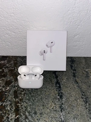 Apple AirPods Pro 2nd Gen hörlurar - Säljer ett par vita Apple AirPods Pro (2nd generation) med laddningsetui. Trådlösa in-ear hörlurar med stilren design och kompakt form. Perfekta för musik, samtal och träning. Levereras i originalförpackning.