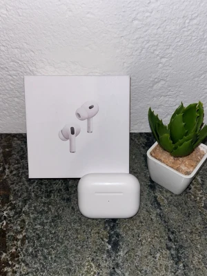Apple AirPods Pro (2nd gen) hörlurar - Snygga och trådlösa Apple AirPods Pro (2nd generation) med vitt laddningsetui. Hörlurarna har en stilren och kompakt design, perfekt för musik, samtal och gaming. Levereras i originalförpackning.