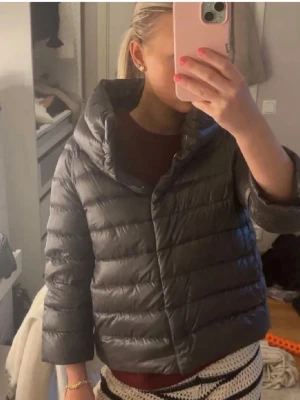 Grå herno jacka med hög krage - Säljer en grå herno pufferjacka med hög krage och quiltad design. perfekt både för kyligare dagar och sommarkvällar. Den är lätt vadderad och har trekvartsärmar för en modern look. 