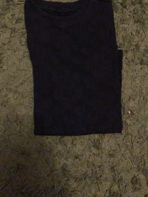 Svart basic t-shirt i bomull - En enkel svart t-shirt med rund hals och korta ärmar. Perfekt att matcha med jeans eller shorts för en clean och stilren look. Tillverkad i mjuk bomull som känns skön mot huden.