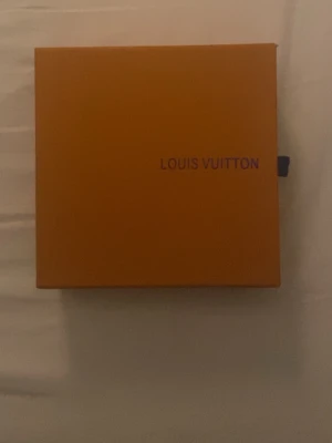 L V bälte i originalask - Exklusivt bälte från L V, levereras i original orange ask och dustbag med logotyp. Perfekt accessoar för att lyfta din outfit med en lyxig touch. Klassisk design och högkvalitativt material som ger en tidlös känsla.
