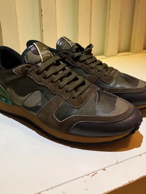 Valentino Rockrunner  - Snygga och exklusiva sneakers från Valentino Garavani i camouflage-design. Sparsamt använda och i jättebra skick – inga större slitage. Bekväma, stabila och av hög kvalitet. 100% äkta vid funderingar hör av er 