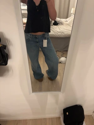 Ljusblåa vida jeans från zara - Säljer ett par ljusblåa jeans från zara med lös och rak passform. Jeansen har klassisk femficksdesign, hög midja och vida ben. Perfekta för en avslappnad och trendig stil. Materialet är denim i bomull.