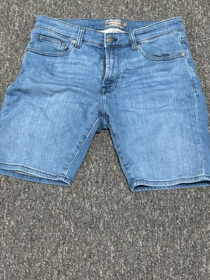 Blå jeans från Dressmann - Snygga blå jeans från Dressmann med klassisk femficksdesign och normal passform. Jeansen har bälteshällor, knappgylf och är tillverkade i ett mjukt denimtyg som passar perfekt till din vardagsstil.